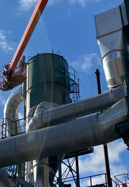 Man cleaning huge metal container